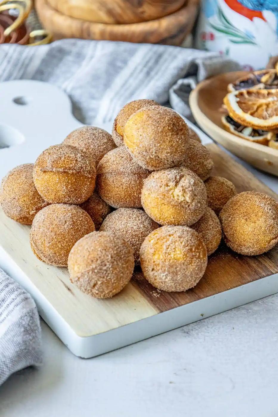 Cinnamon sugar doughnut holes on a cutting board.