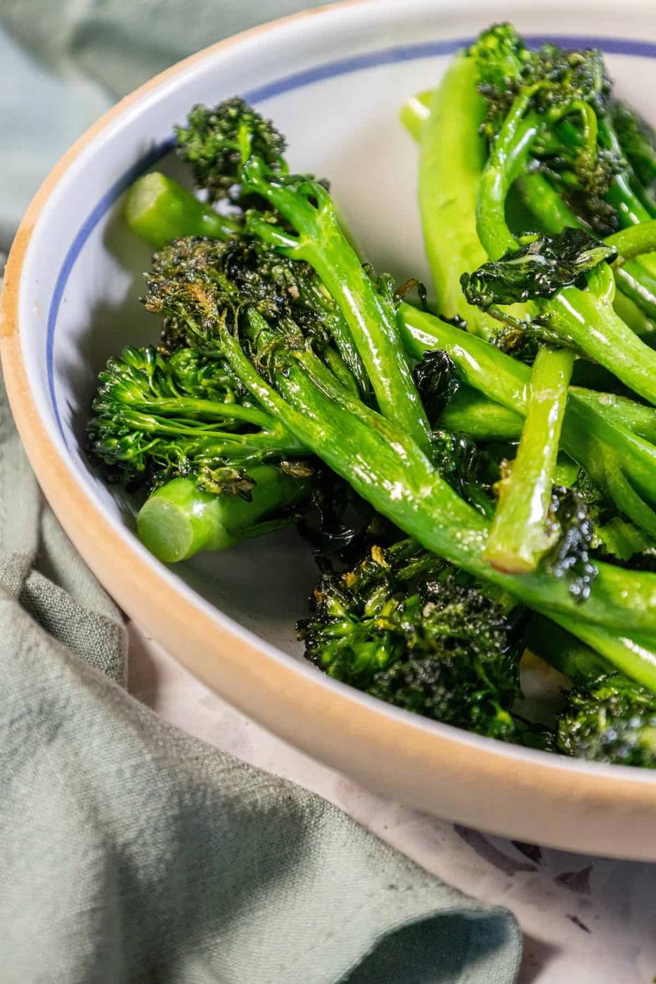 Pan-fried broccolini in a bowl on a table.