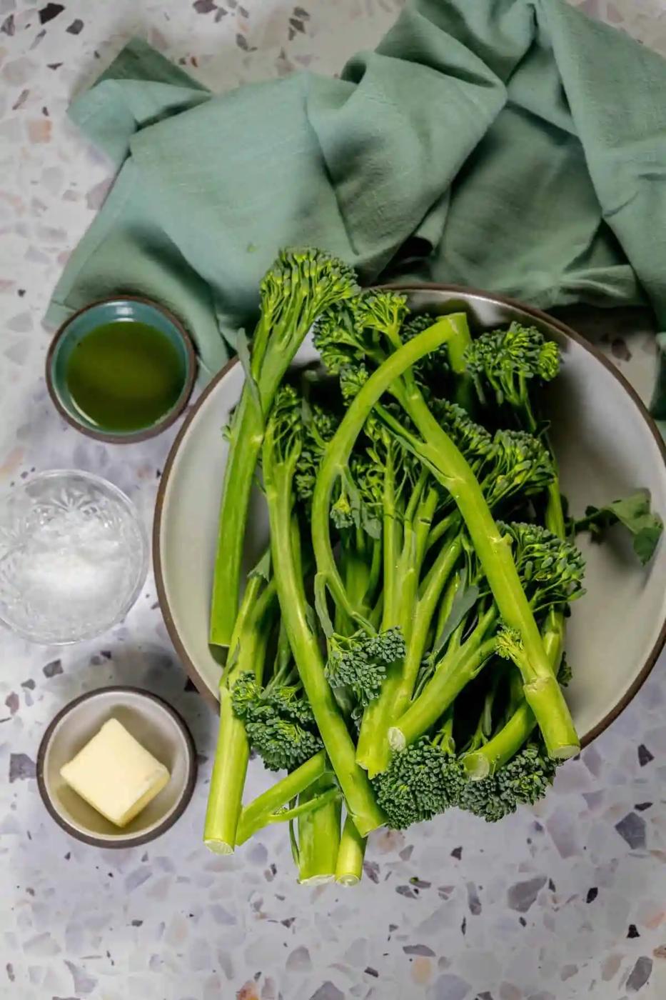 Sauteed broccolini with butter, served in a bowl on a table.