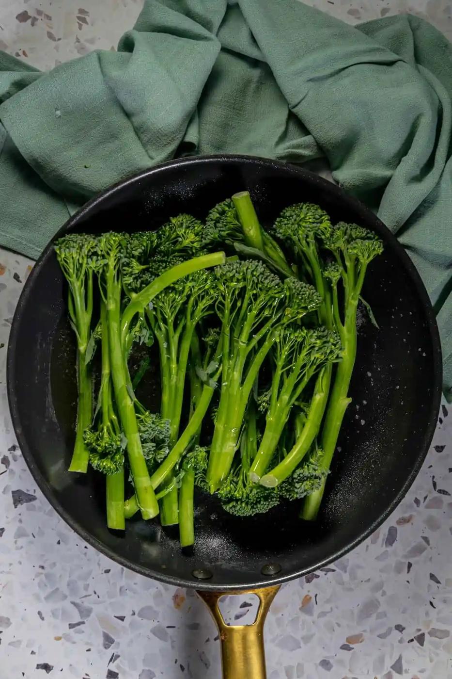 A sauteed broccolini dish cooked in a frying pan.