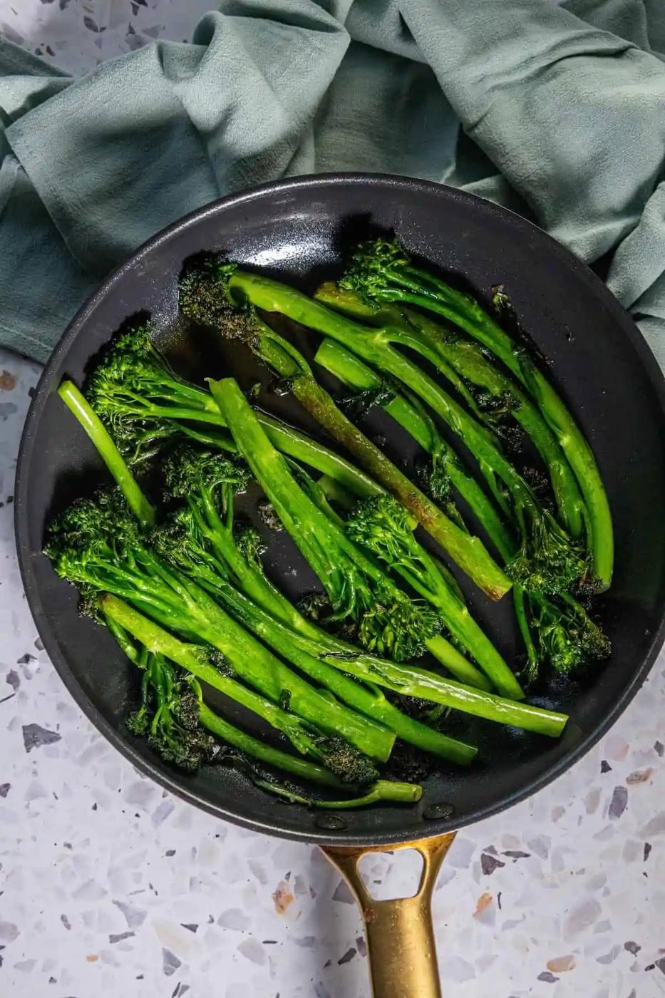 Pan fried broccolini on a table.