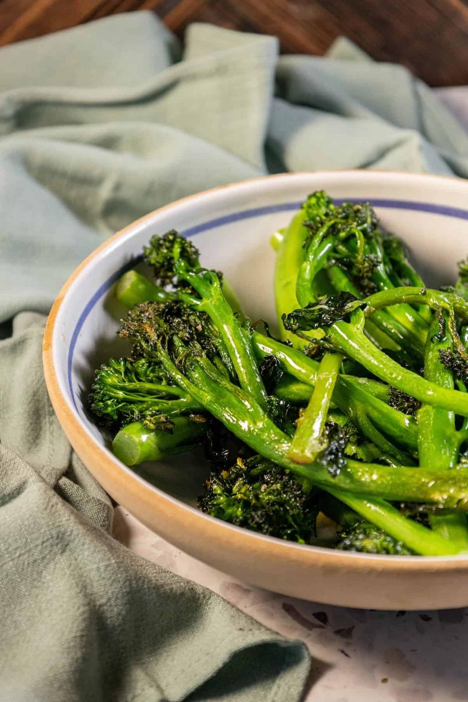 A bowl of broccoli on a table.