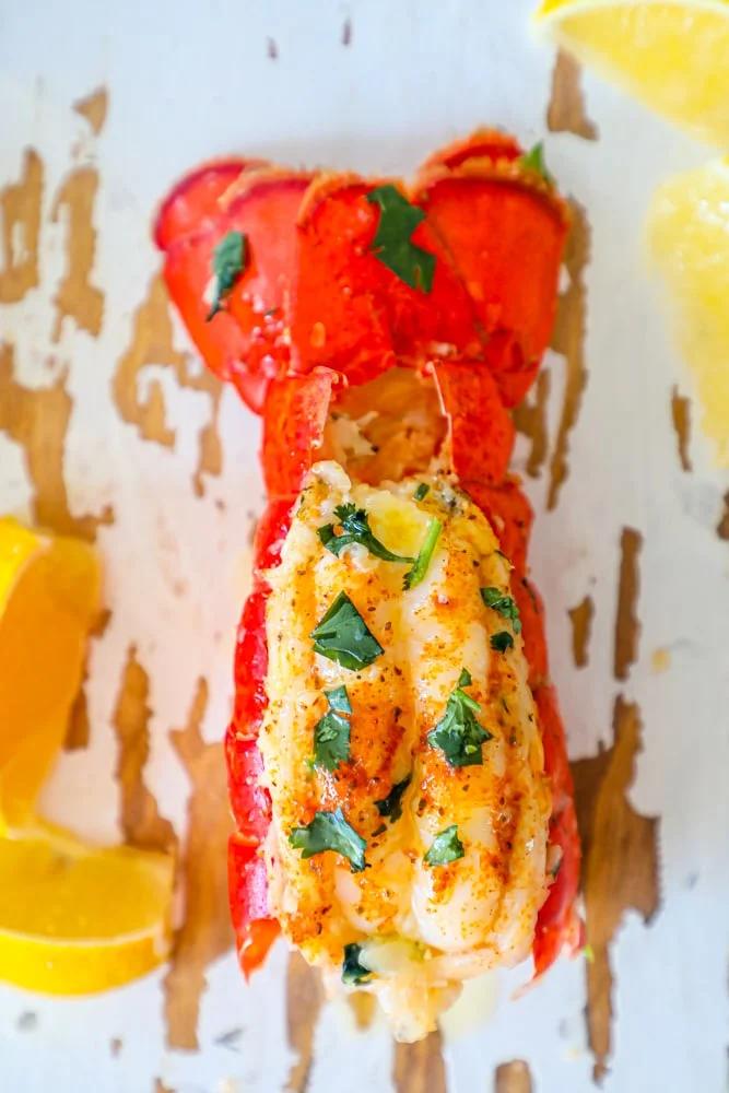 A flavorful lobster, stuffed with herbs and served on a pristine plate.