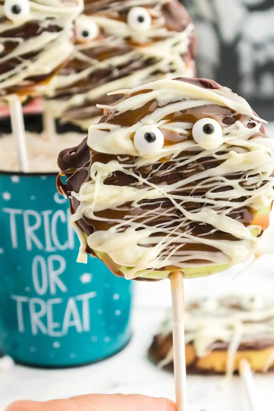 picture of caramel apple mummies in a blue trick or treat bowl