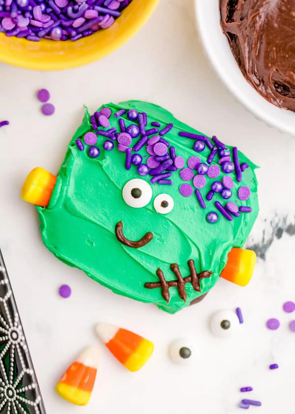 A Halloween cookie with green frosting and candy canes, perfect for easy Frankenstein cookies.