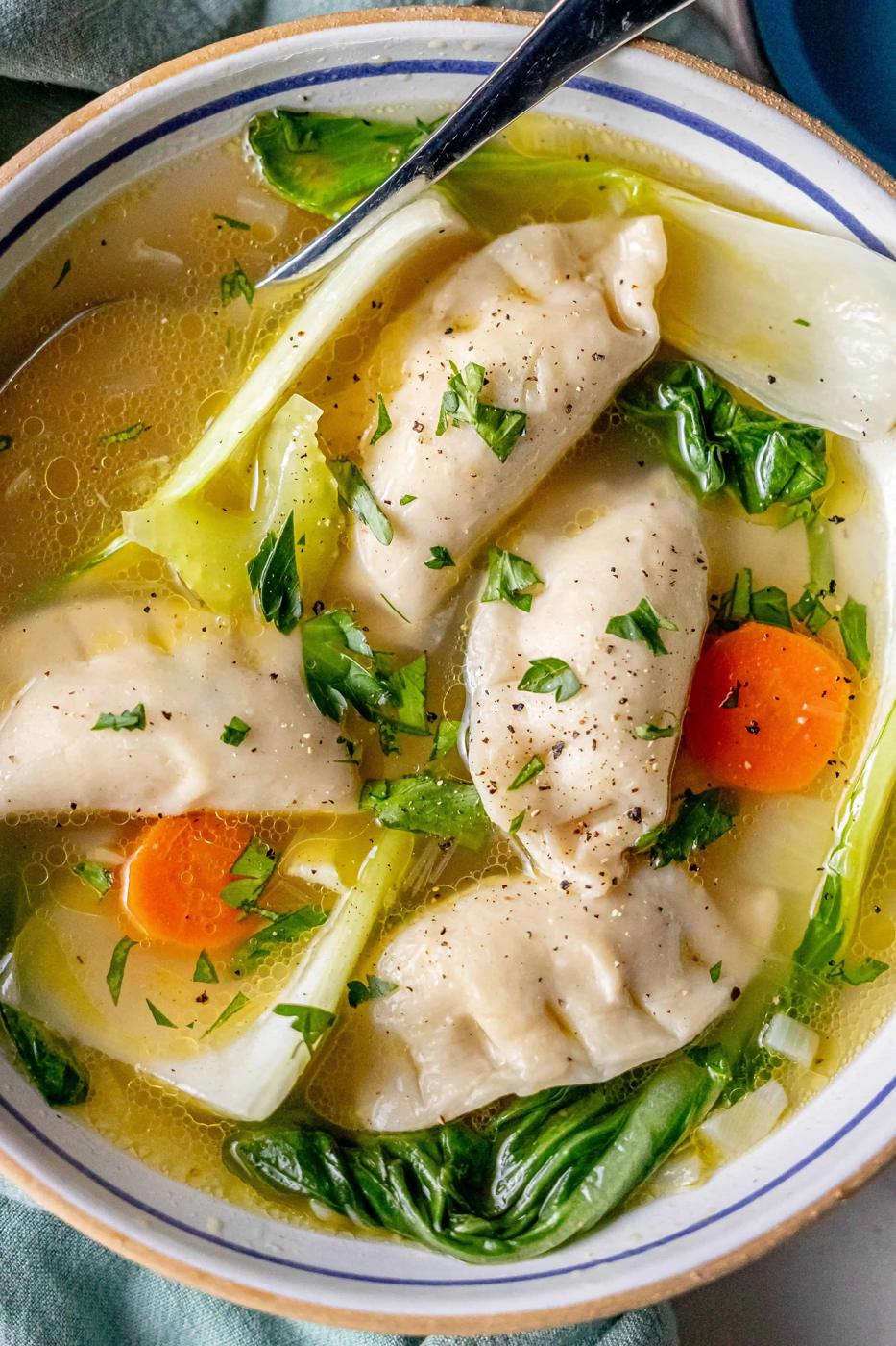 A 15-minute potsticker soup featuring a bowl of savory broth with dumplings, bok choy, and carrot slices, garnished with chopped herbs.