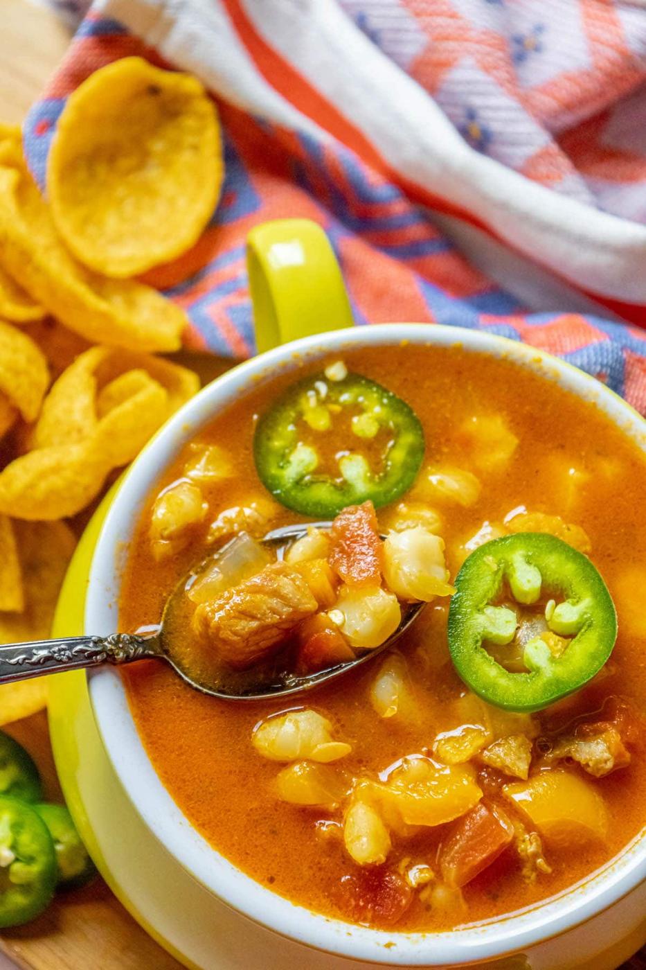 A bowl of Mexican bean soup with jalapenos and tortilla chips with a hint of pozole rojo.