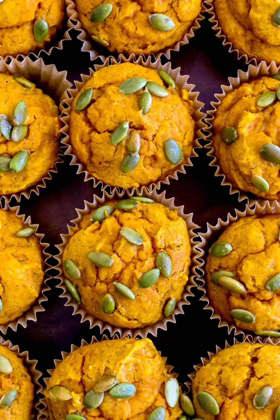 Moist pumpkin muffins with pumpkin seeds on top.