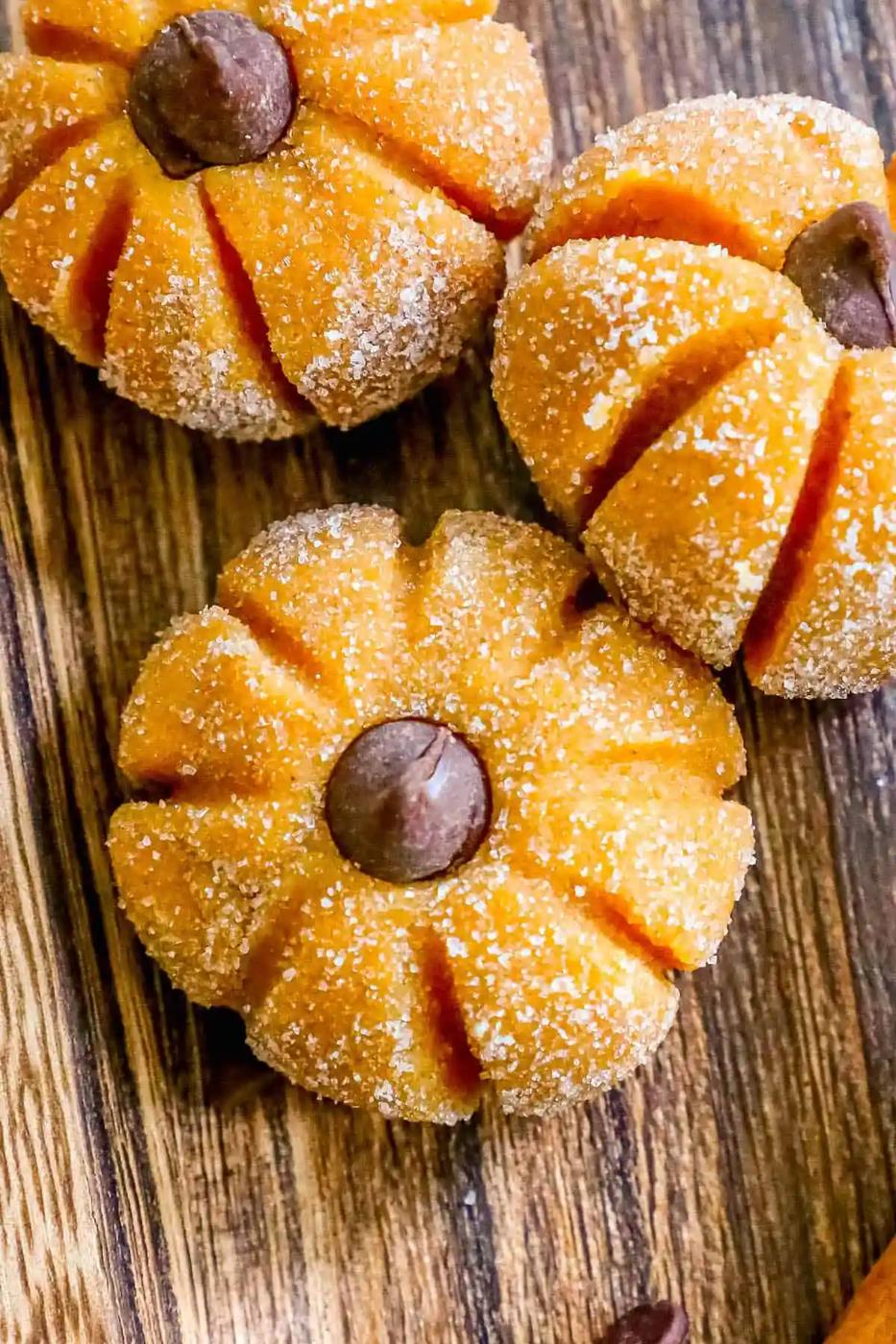 Pumpkin cheesecake cookies on a wooden cutting board.