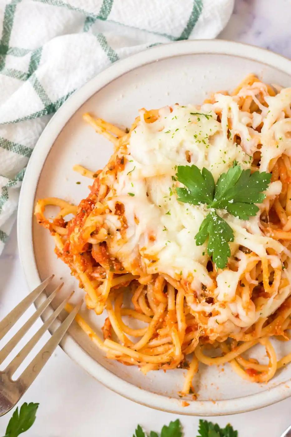 Cheesy Baked Spaghetti with Parmesan cheese and parsley.