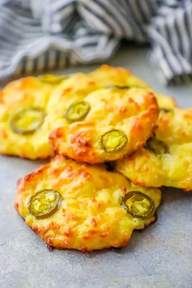 Cheesy jalapeno cheesecakes on a blue background with low carb cheese bread.
