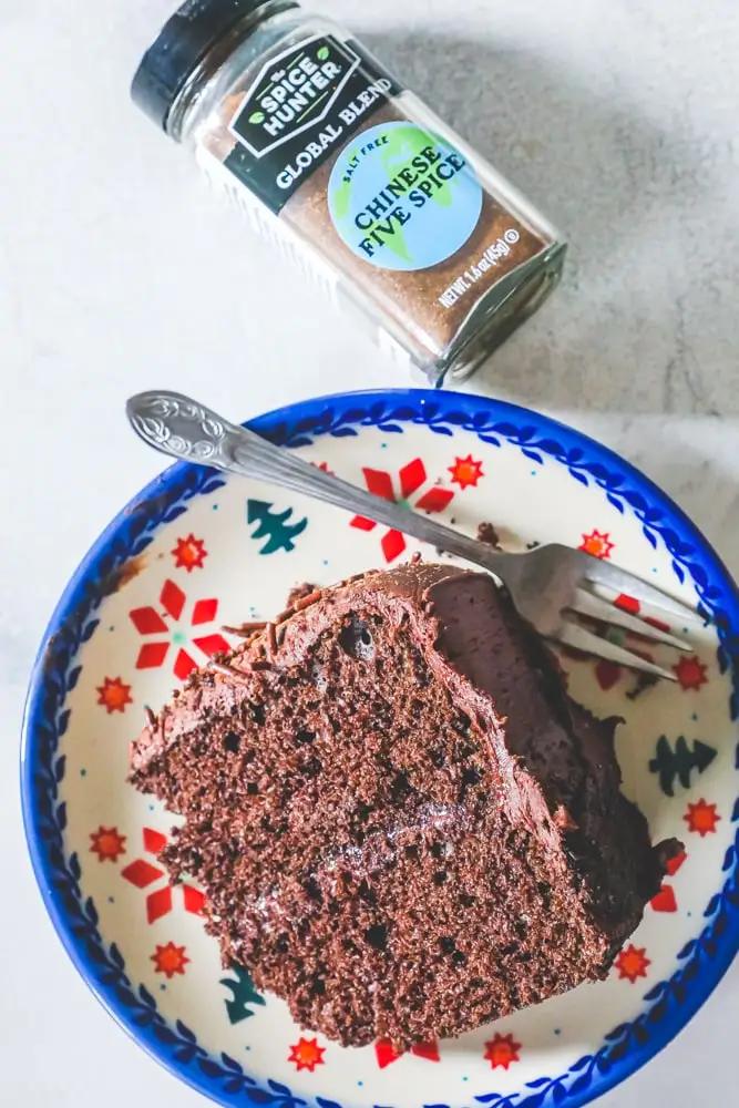 A piece of Chinese Five Spice Chocolate Cake on a plate with a fork.