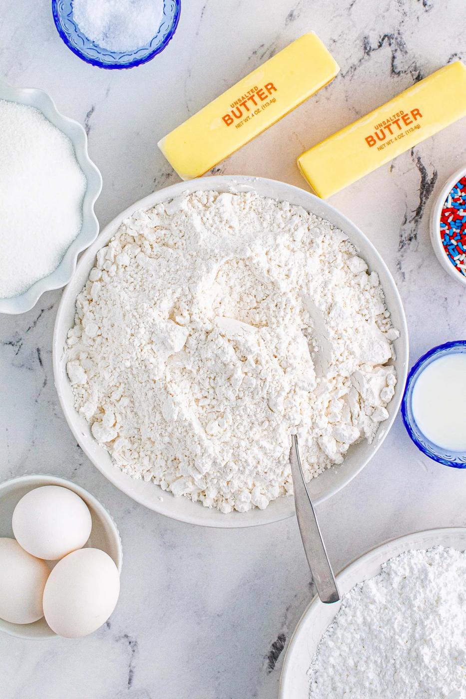 flour with eggs, butter, and sugar around it