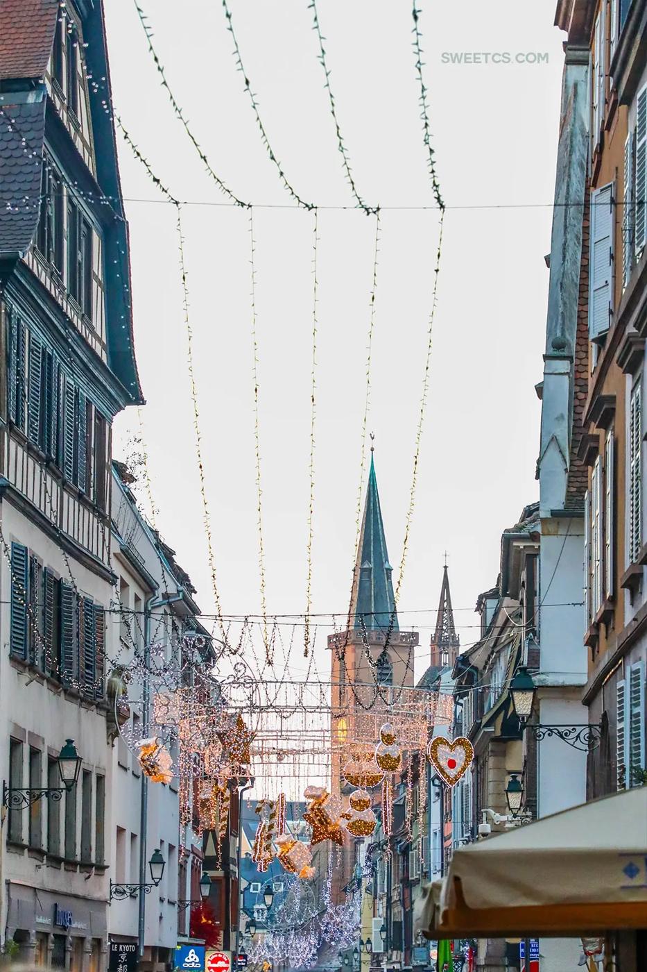 A festive street featuring Christmas lights in Strasbourg, France.