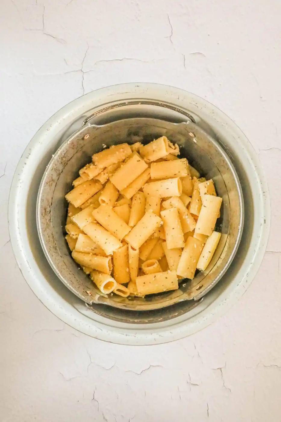 picture of pasta chips in an air fryer bowl with cheese and seasoning
