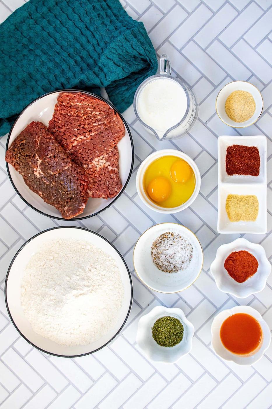picture of cube steak, flour, herbs, spices, egg on a table
