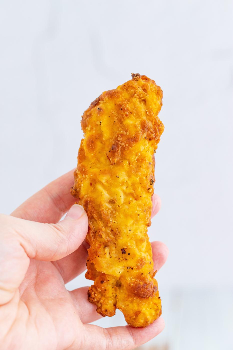 chicken tender being held up