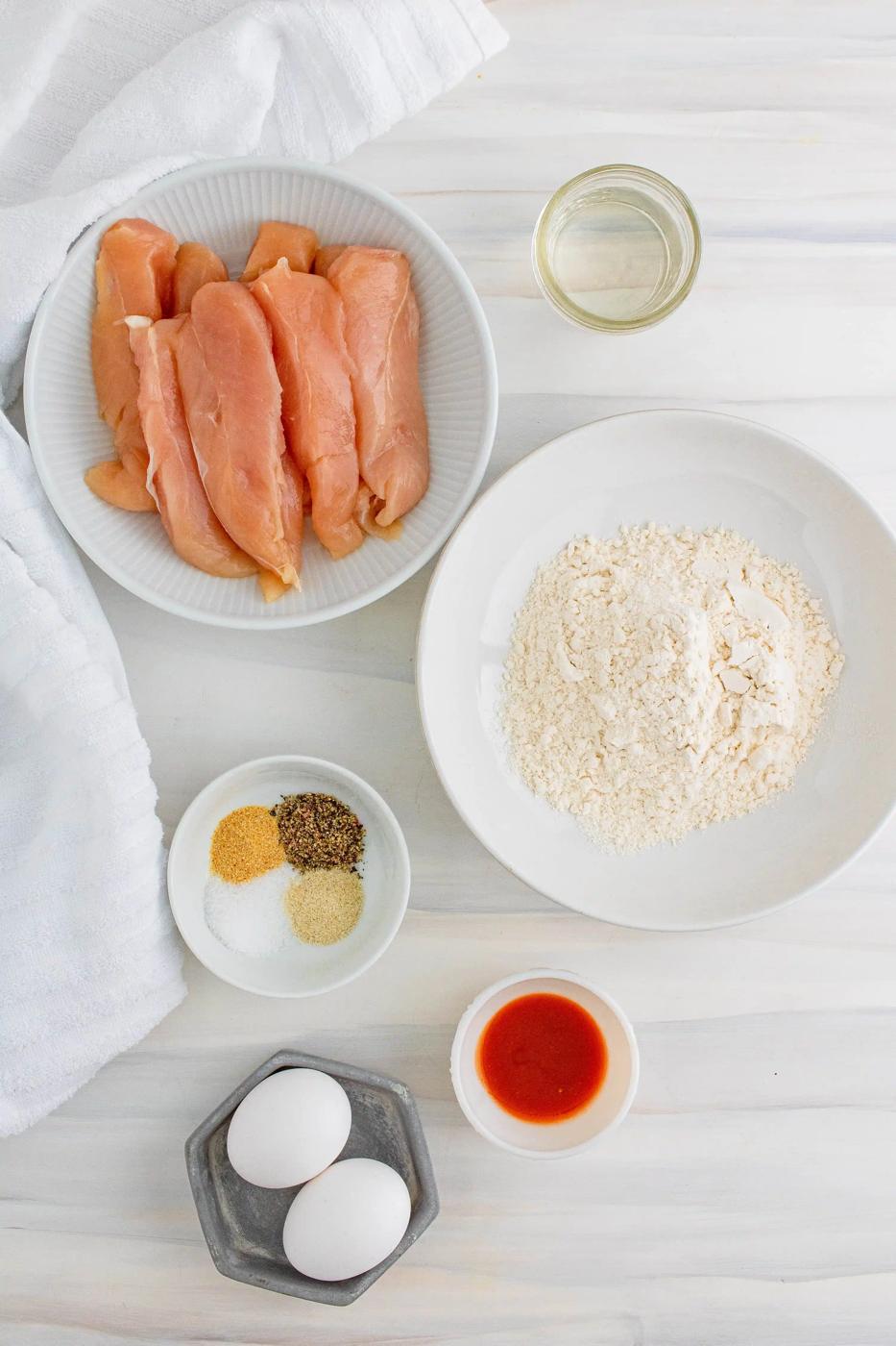 Chicken tenders on white table.