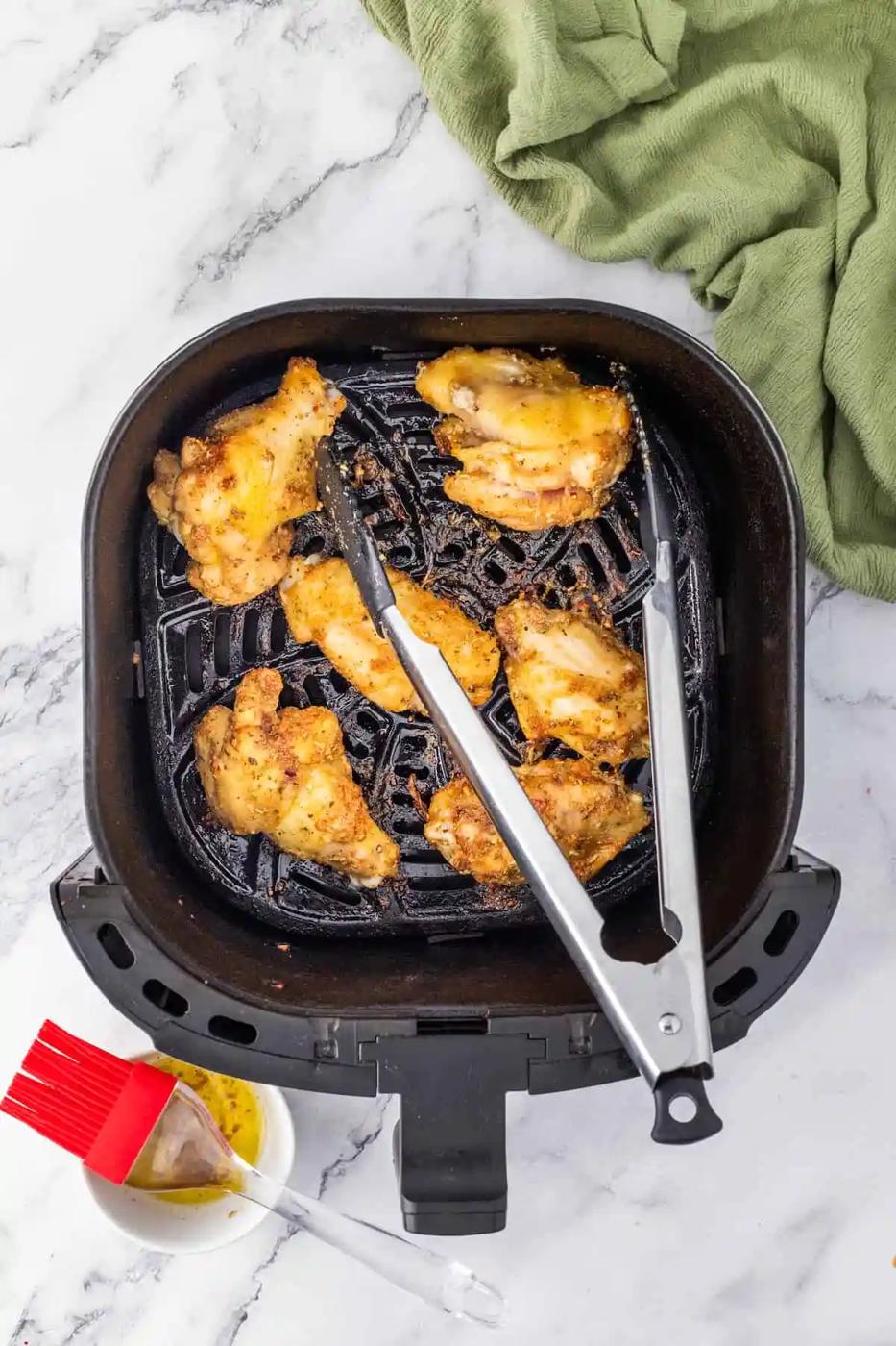 Chicken wings cooked effortlessly in an air fryer on a sleek marble countertop.