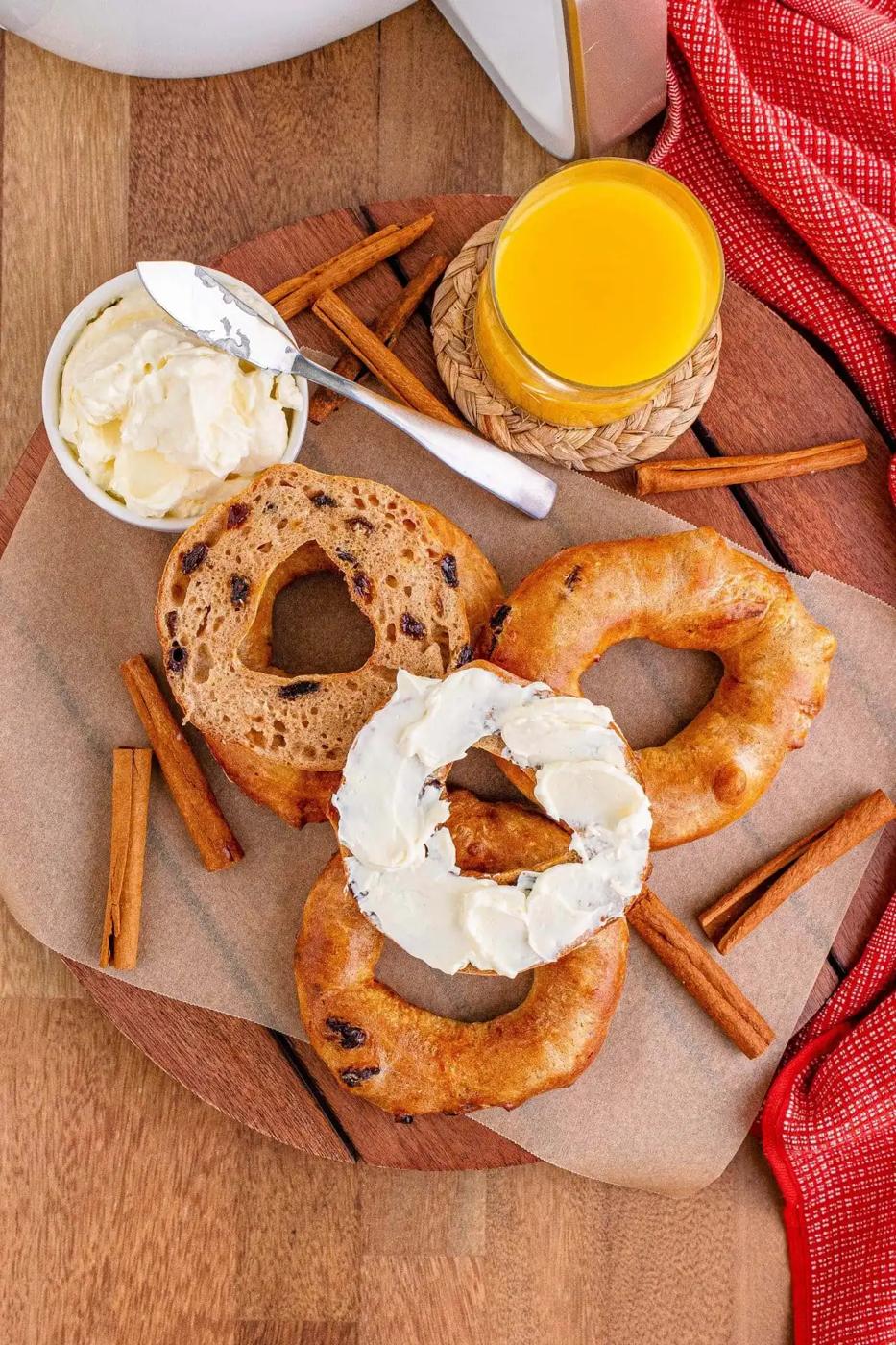 A tray of air-fried bagels and cinnamon sticks on a wooden table.