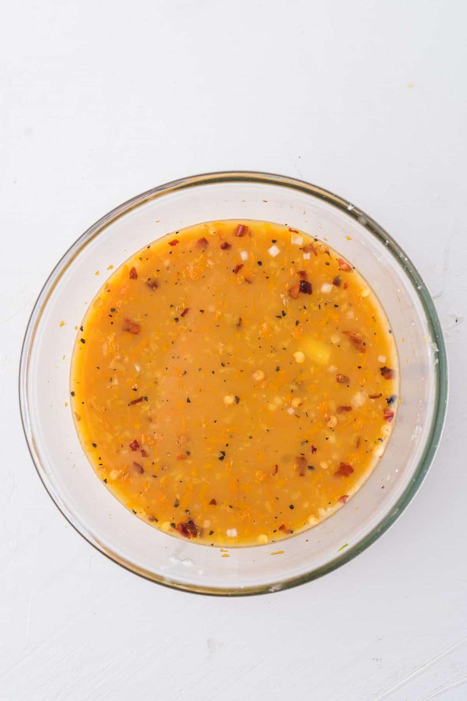 An Air Fryer-cooked bowl of Orange Chicken sauce on a white background.
