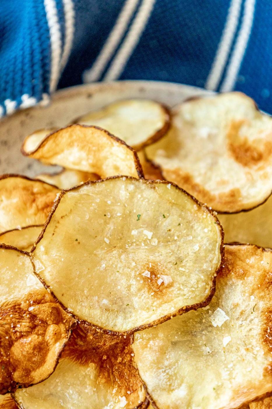 picture of air fried potato chips piled on a plate and seasoned with garlic salt