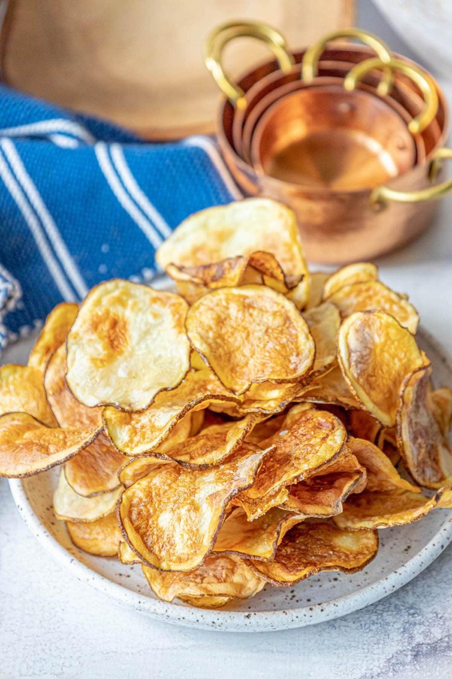 picture of air fried potato chips piled on a plate and seasoned with garlic salt