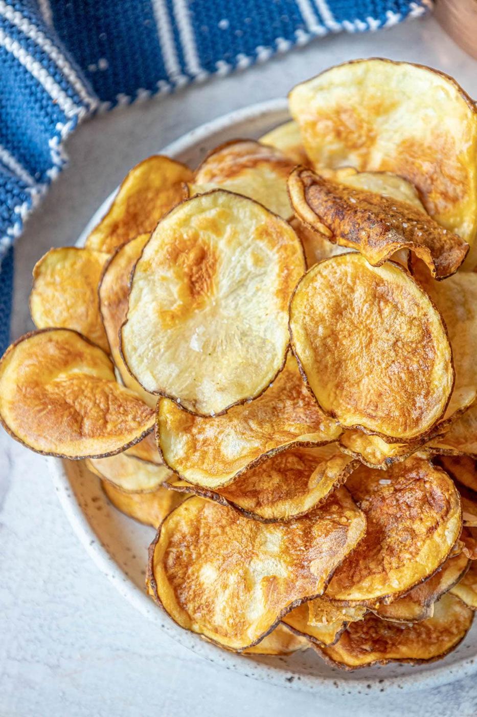 picture of air fried potato chips piled on a plate and seasoned with garlic salt