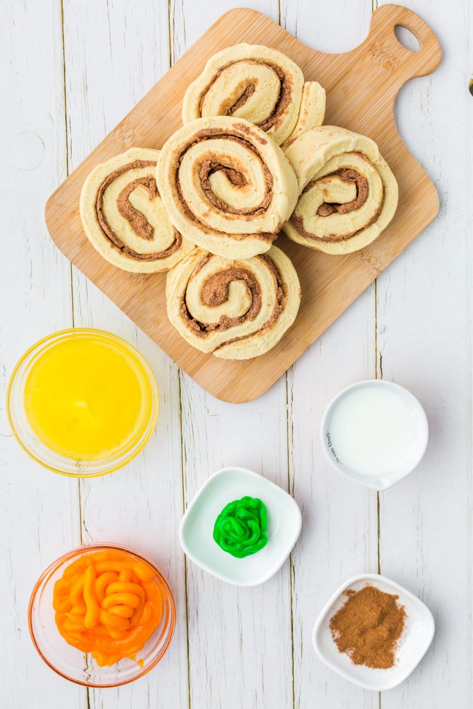 cinnamon rolls, icing, milk, pumpkin spice, butter on a table