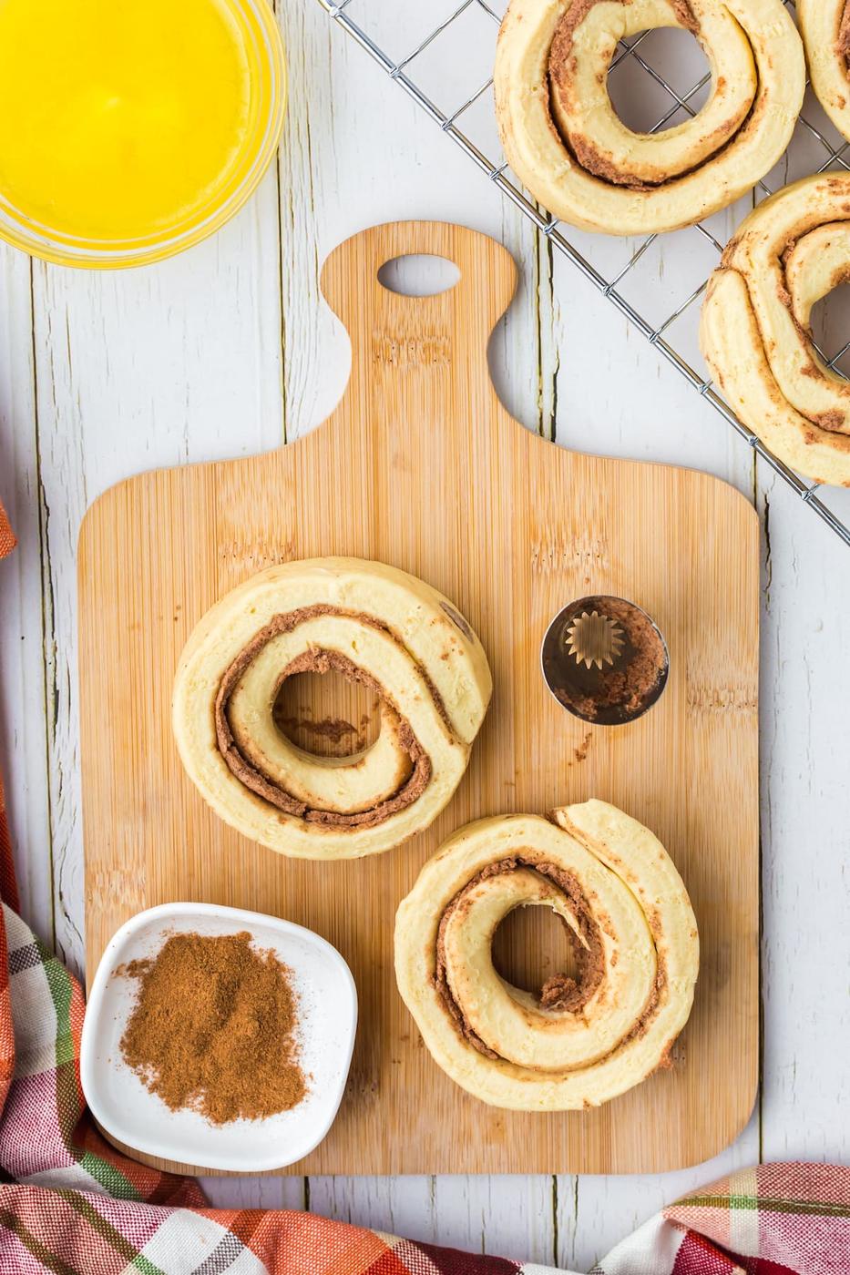 cinnamon rolls with the middles cut out of them to make a donut shape