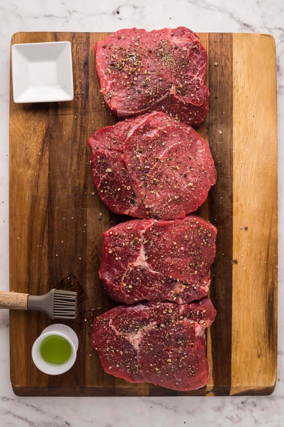 Longhorn Steakhouse Parmesan Crusted Steak presented on a cutting board with a knife and fork.