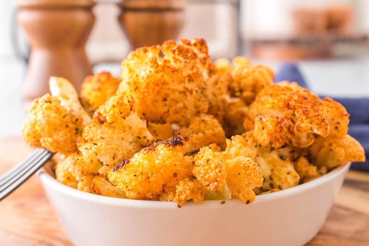 browned seasoned cauliflower in a white bowl