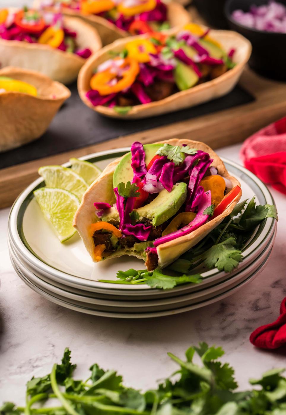 picture of air fried tofu taco on a table topped with avocado peppers and cabbage