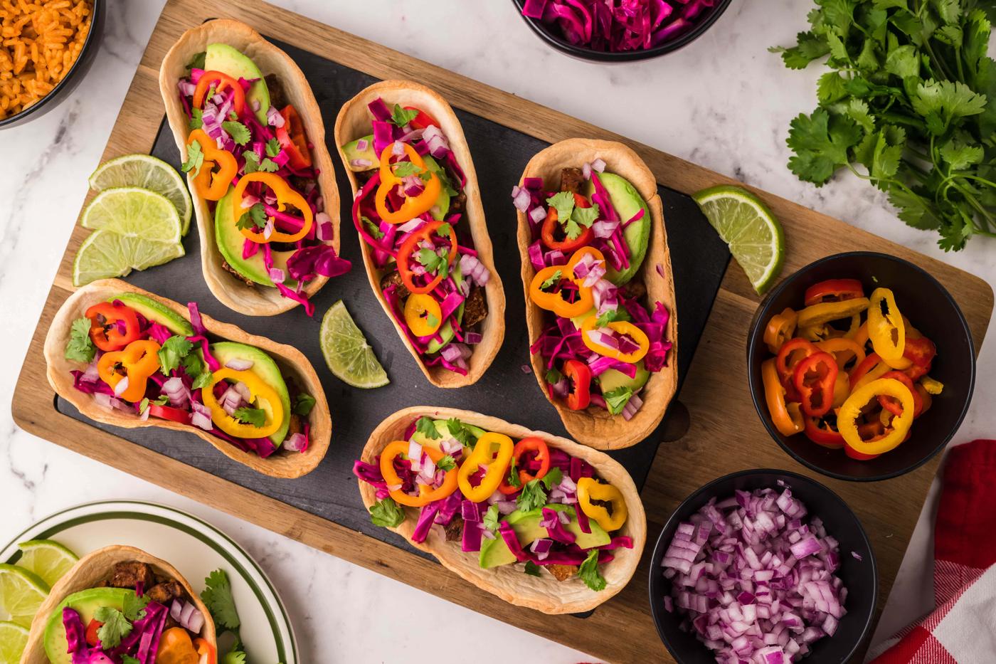 picture of air fried tofu taco on a table topped with avocado peppers and cabbage