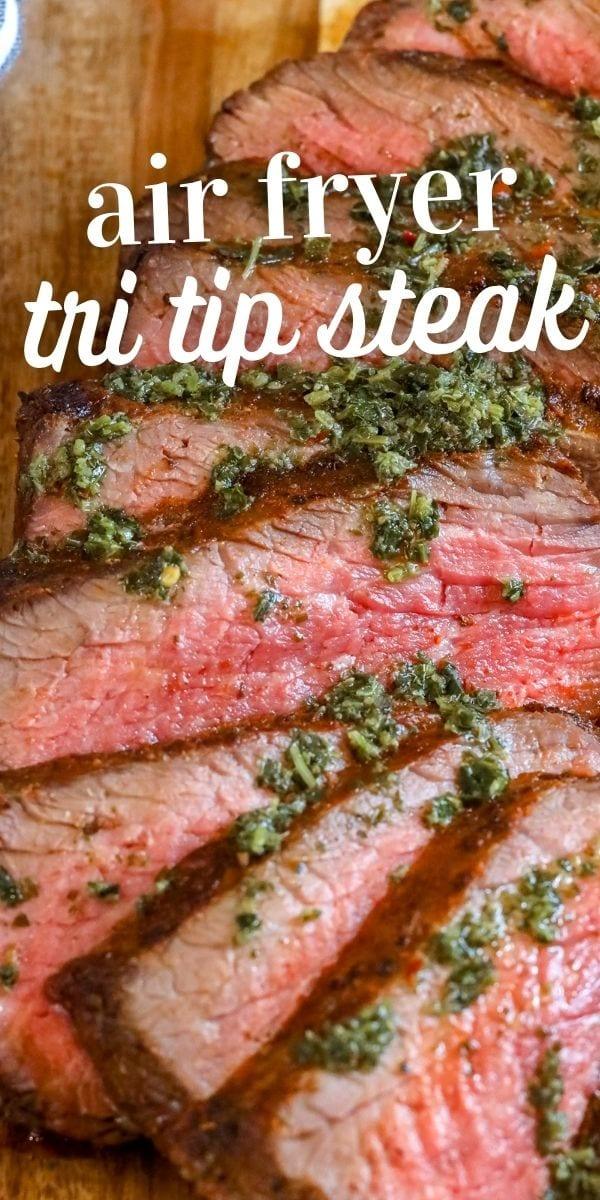 picture of sliced tri tip steak on a cutting board with chimichurri sauce on top