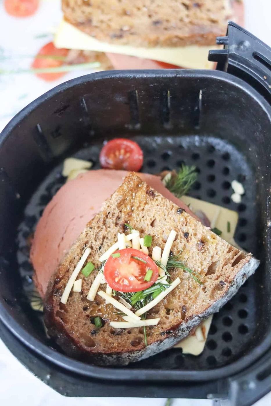 A vegan sandwich cooked in an air fryer with tomatoes and herbs.