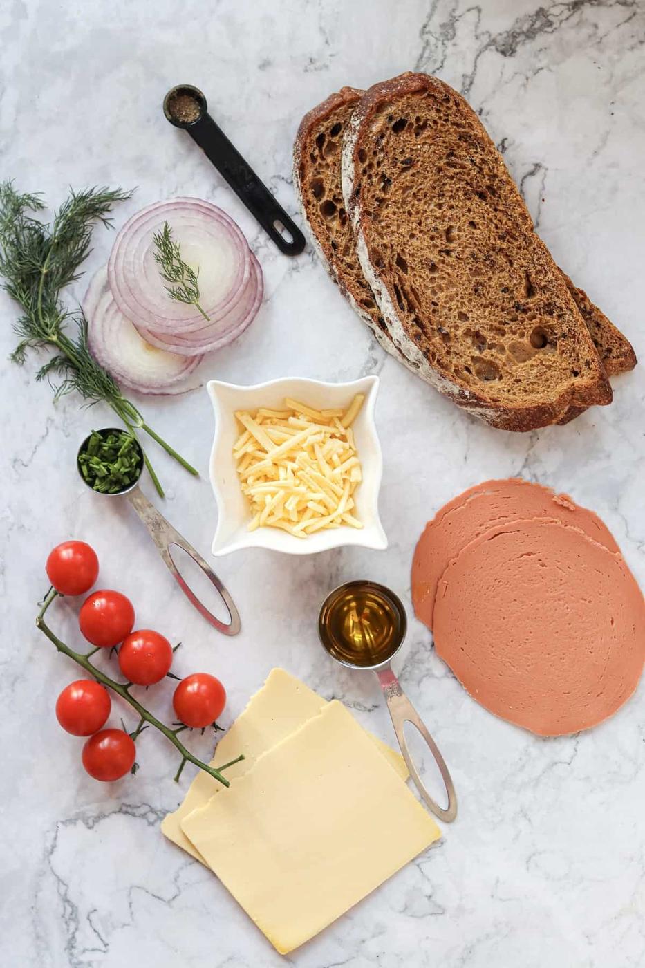 The vegan sandwich includes bread, tomatoes, and cheese.