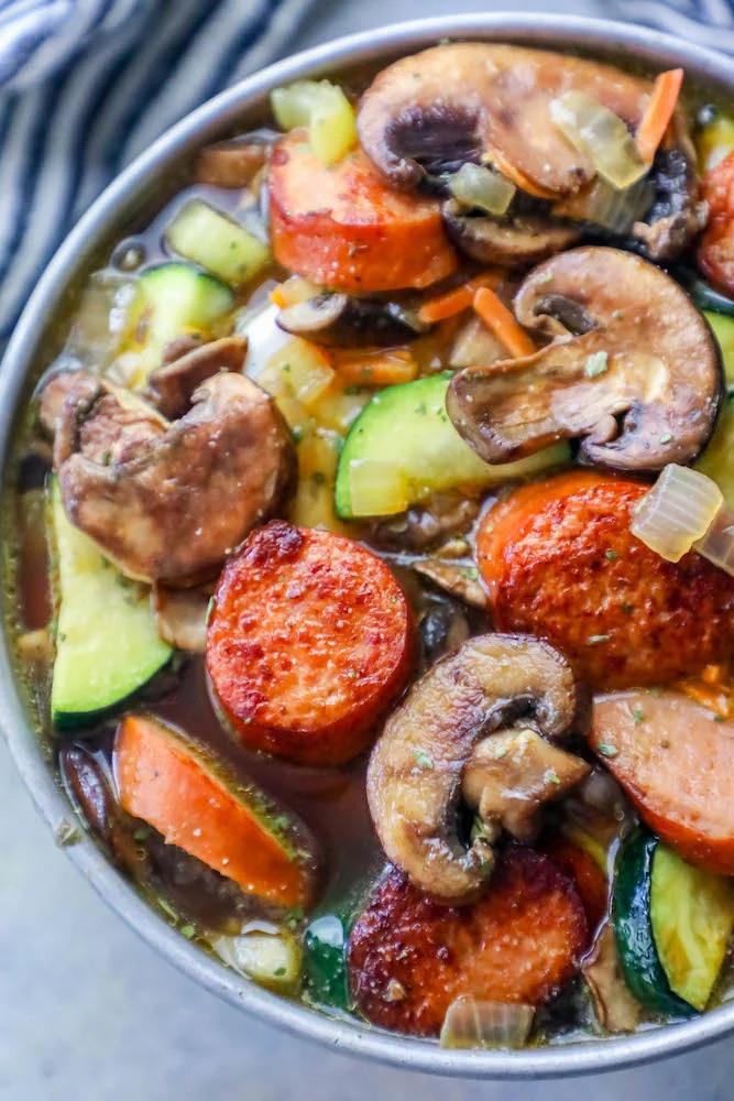A delicious sausage and vegetable soup recipe with mushrooms, zucchini, and andouille sausage.