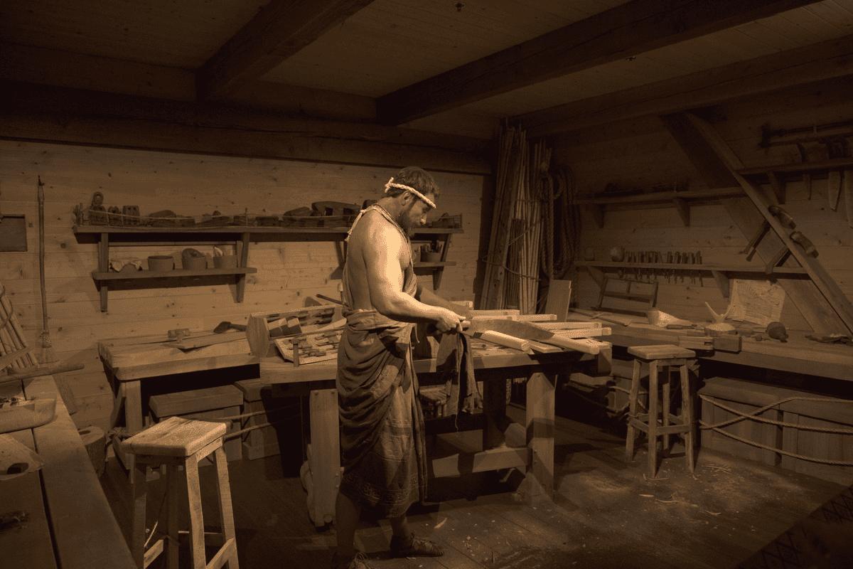 A man in a robe working in a workshop.
