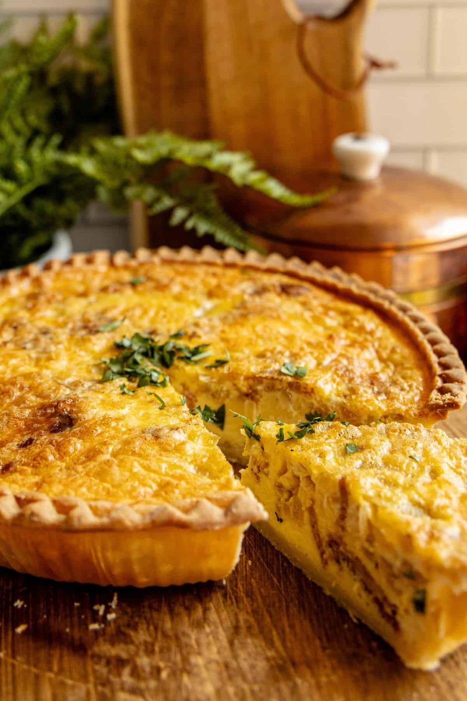 A quiche with a slice missing.