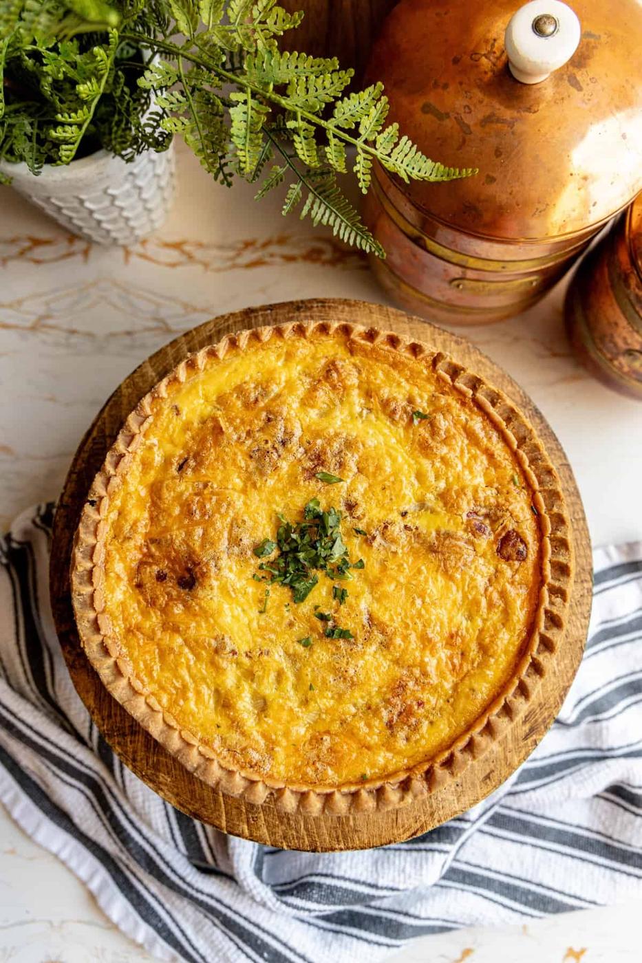A quiche on a wooden plate.