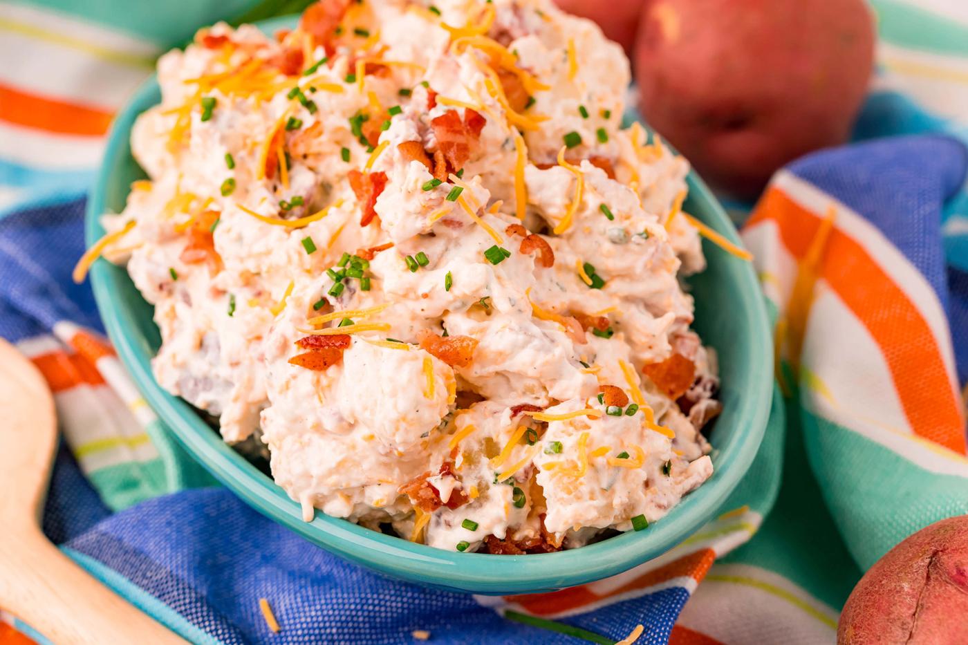 ranch potato salad in a blue bowl on a colorful towel