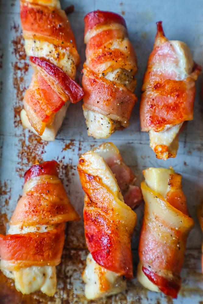 Bacon wrapped chicken bites on a baking sheet.
