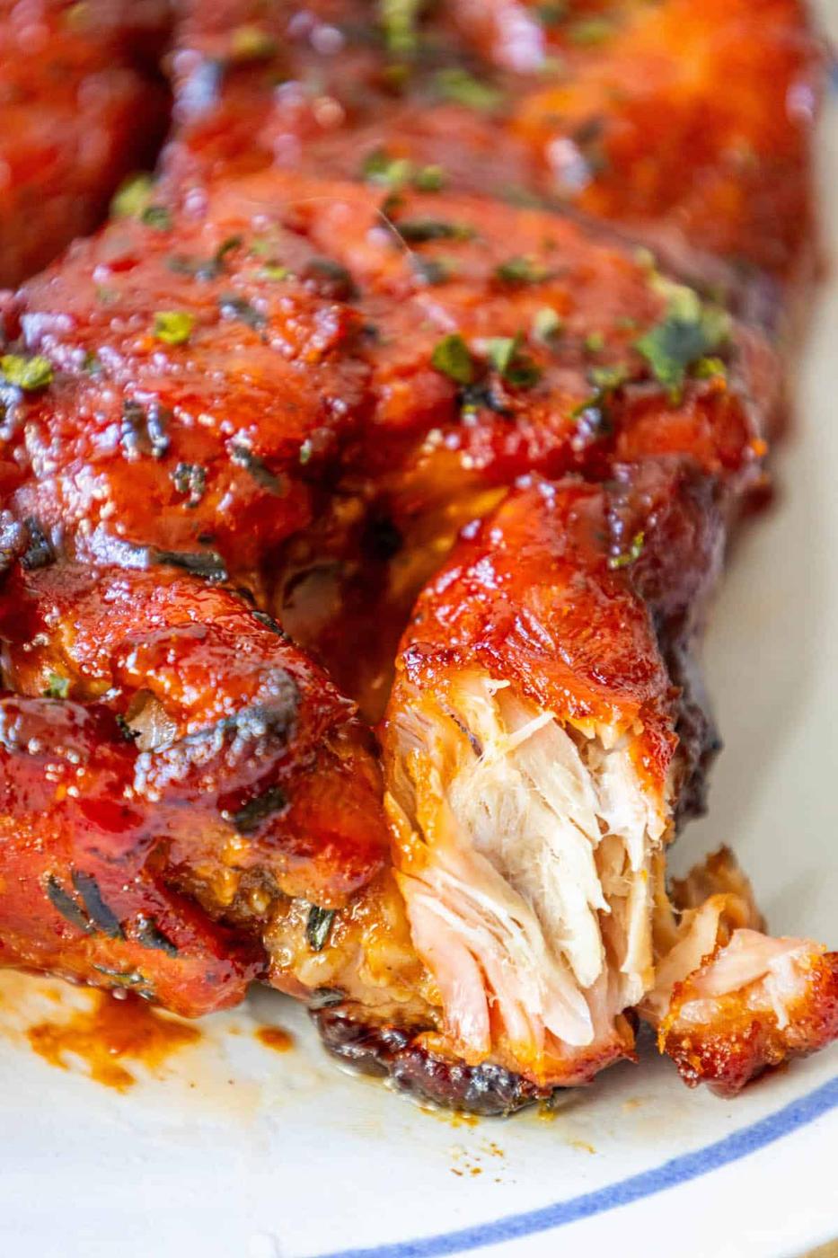 A boneless piece of BBQ chicken on a plate.