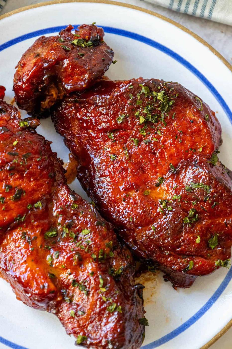 Baked BBQ ribs on a blue and white plate.