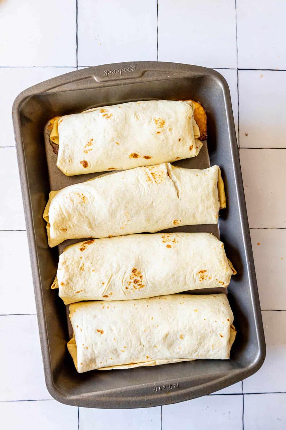 Four baked tortillas on a tiled floor.