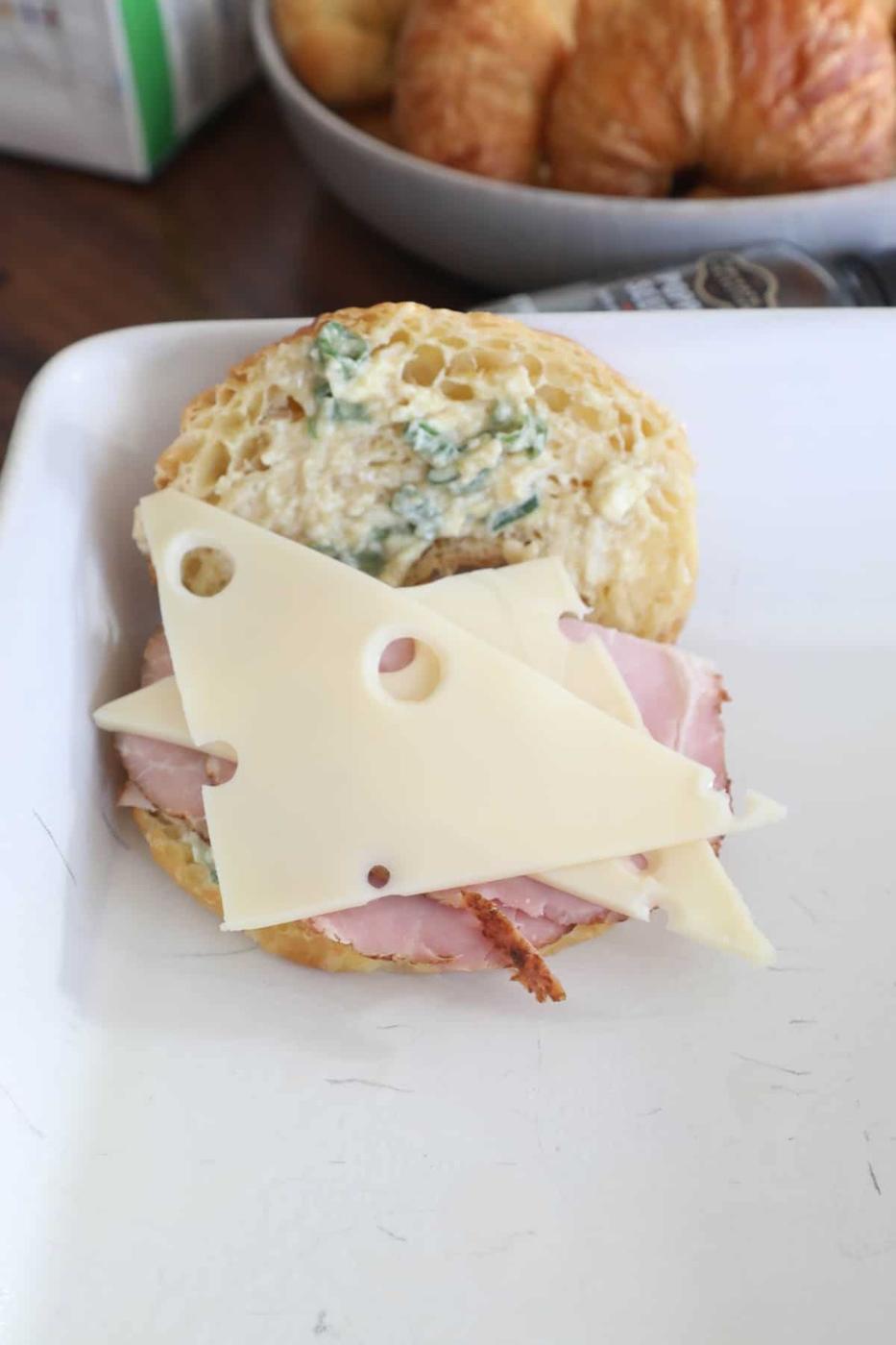A sandwich with ham and cheese on a plate.