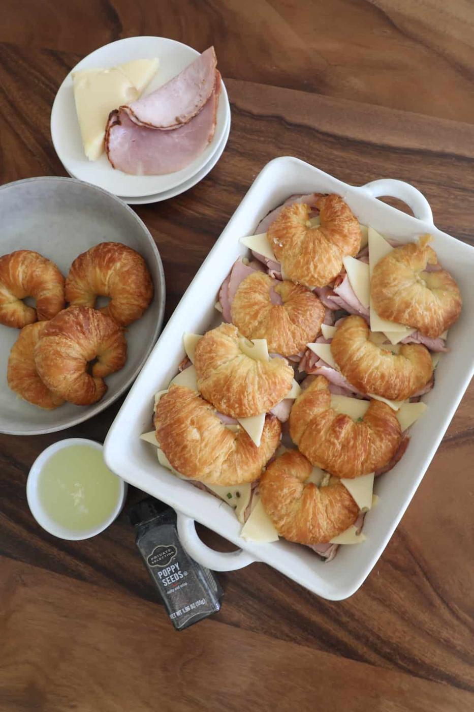 A plate of croissants, ham, and cheese on a table.