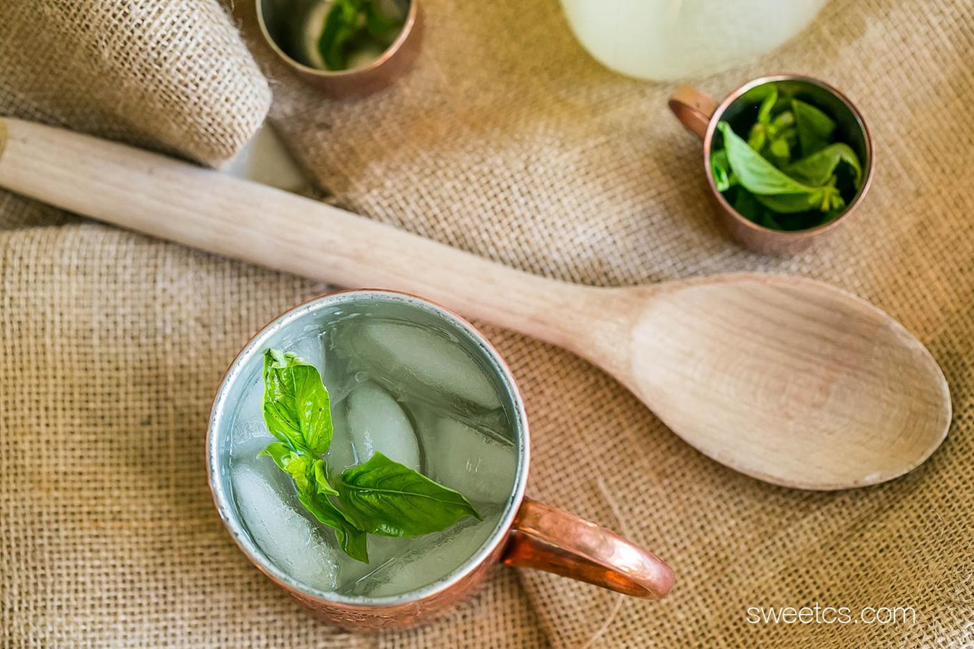 copper cups with lemonade and basil in them