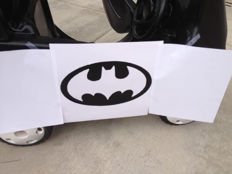 picture of black painted cozy coupe car with a paper stencil over it